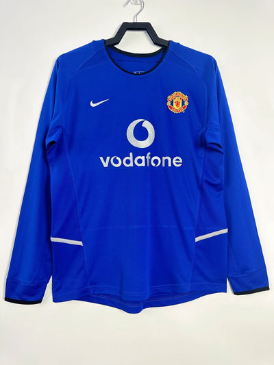 Camiseta Manchester United 2002-2003 Away manga larga, diseño azul con escudo bordado y logo Vodafone.