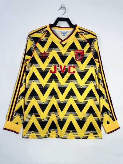 Camiseta Retro Arsenal 1991-1993, diseño "Bruised Banana", Adidas, fondo amarillo con patrones zigzag negro, manga larga.