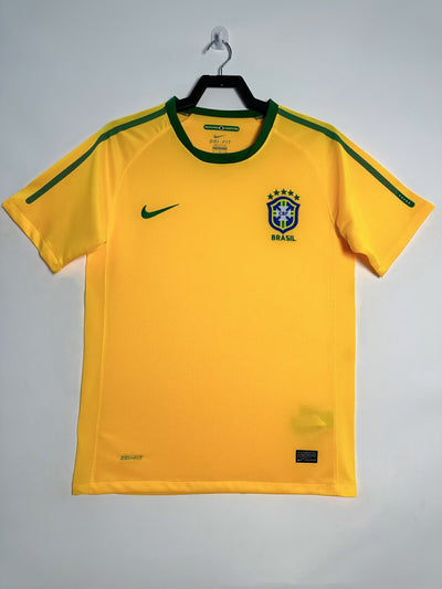 Camiseta Retro Brasil 2010, manga corta, color amarillo con detalles en verde, escudo bordado y logo de Nike.