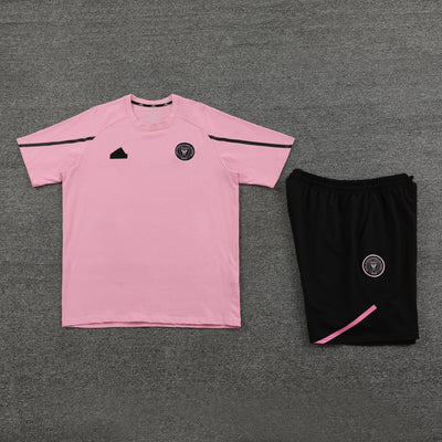 Pink short sleeve T-shirt with black shorts set on a gray background.